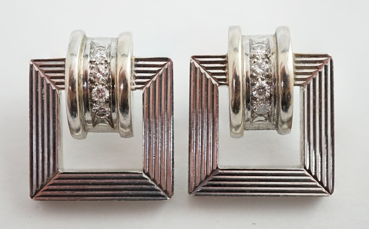 A modern pair of 14k white gold and four stone diamond set buckle style earrings (lacking butterflies)